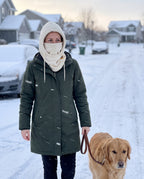Woman walking her dog on a snowy street wearing the cream fleece hood
