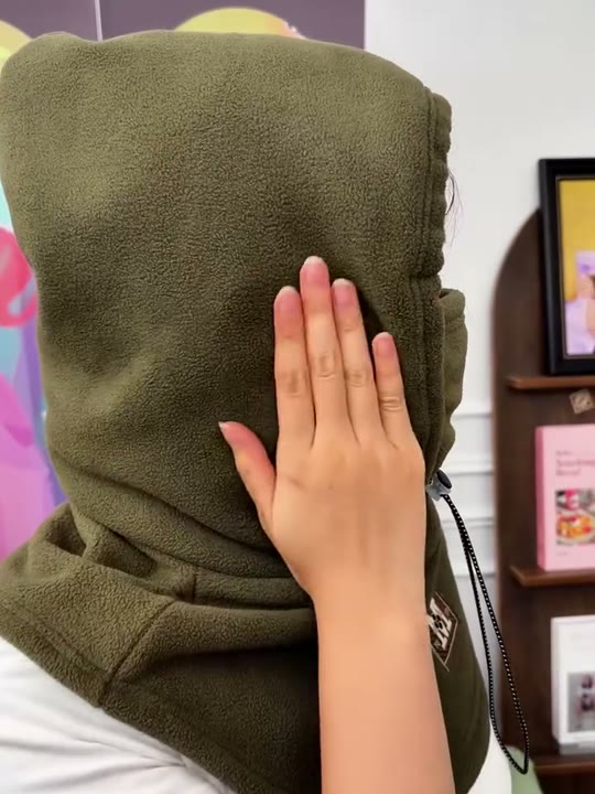 A hand resting on the soft polar fleece of an olive hood